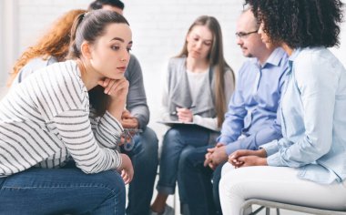 Bağımlılık bilinci. Grup terapisi sırasında stresli düşünceli kadın, boş alan