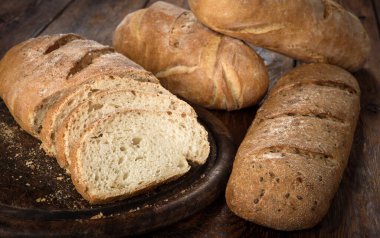 Ücretsiz, hiçbir knead Maya, mayasız sağlıklı organik çavdar buğday yarısı ev yapımı dilimlenmiş ekmek ahşap masa, yuvarlak bir masa üzerine susam ile somun