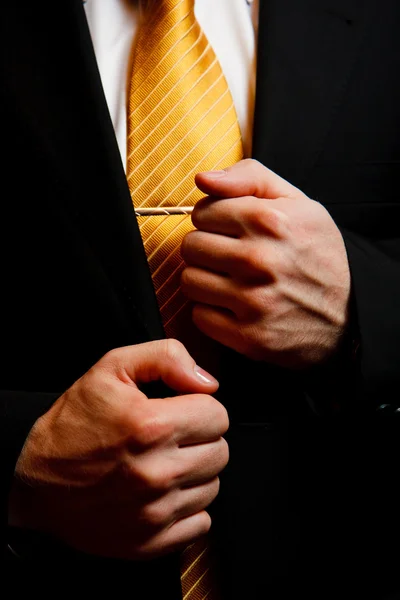 Garnitur mężczyzny z żółty krawat i ręce zbliżenie — Zdjęcie stockowe