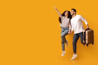 Sıcak Turlar. Bavulu atlayıp uzaklaşan neşeli bir Arap çift, sarı arka planda seyahat teklifi ya da reklamı için fotokopi alanı gösteren heyecanlı Orta Doğulu eşler.