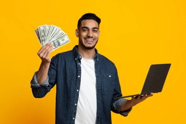 Çevrimiçi hisse senedi ve borsada alım satım yapan, başarıdan keyif alan, kopyalama alanının kopyası olan, gündelik para ve modern dizüstü bilgisayarı olan orta doğulu pozitif bir genç.