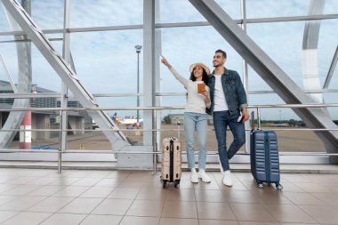 Tatil teklifi. Havalimanında uçuşunu bekleyen neşeli genç Arap çiftin portresi, terminalde bekleyen mutlu Orta Doğulu eşler, seyahat etmeye hazır, kopyalamaya hazır.