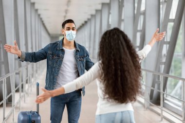 Uçuşlar devam ediyor. Tıbbi maske takan neşeli bir Arap, havaalanına vardıktan sonra kız arkadaşıyla buluşuyor, kucaklaşmak için kollarını açıyor, uzun süre ayrı kaldıktan sonra birbirlerini gördüklerine seviniyorlar.