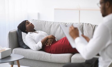 Genç siyahi bir kadının psikologla randevusu var, ofiste koltukta uzanıyor, profesyonel sorunlarıyla ilgili danışmanlık yapıyor. Klinikteki psikoterapistle iletişim kuran Millennial kadın hasta