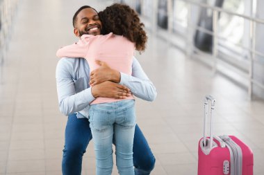 Tanış ve Selamla. Gülümseyen Afrikalı Amerikalı adam havaalanına vardıktan sonra mutlu kızına sarılıyor, siyah kız babasına sarılıyor, eve dönüyor ya da tatil yolculuğuna çıkıyor, bedava fotokopi çekiyor.