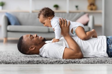 Baba sevgisi. Mutlu, genç, siyah bir baba evde yeni doğmuş sevimli bir bebekle bağ kuruyor, Afro-Amerikan bir adam tatlı oğluyla oturma odasında oynuyor, birlikte vakit geçiriyorlar.