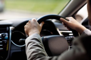 Satış ve kiralık taşıma. Şoför elinde direksiyon, yeni arabasında oturuyor, işe giderken iyi yolculuklar. Genç işadamı yolda modern yeni bir araba kullanıyor. Kamaranın manzarası, kırpılmış, kapatılmış, boş alan.