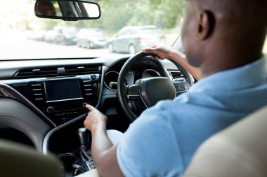 Siyah adamın yeni arabanın ön koltuğunda oturduğu, test sürüşü yaptığı, müziği açtığı, otomobil stereo sistemini kontrol ettiği, yakın plan çekimleri, kopyalama alanı. Tanınmayan Afrikalı Amerikalı şoför işe gidiyor.