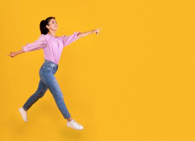 Heyecanlı Ermeni kadın sarı stüdyo arka planında, boş alanda koşup fotokopi çekiyor. Mutlu milenyum hanımları gülümseyip reklamlara ya da anonslara işaret ediyor.