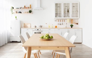 Konforlu modern mutfak döşemesi, mobilya, ahşap kırsal masa. Yemek masası ve mutfak gereçleri raflarda olan boş oda arkaplanı