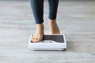 Tanınmayan genç Hintli kadın ağırlığını ölçmek için teraziye basıyor. Bin yıllık kadının zayıflama diyetinin sonucunu kontrol etmesi. Sağlıklı yaşam kavramı