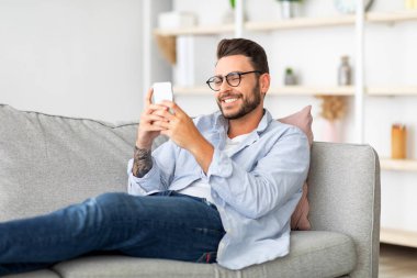 Harika bir mobil uygulama. Akıllı telefon kullanan, sosyal ağlarda mesajlaşan ve sörf yapan, evdeki koltukta oturan, fotokopi çeken mutlu bir adam. Millennial Man internette geziniyor, cep telefonunda uygulama kullanıyor