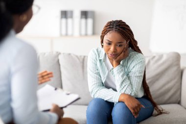 Üzgün siyahi kadın akıl hastanesinde psikolojik yardım alıyor, danışman ile iletişim kuruyor. Psikoterapist mutsuz Afrika kökenli Amerikalı kadın travma sonrası stres bozukluğu ya da duygusal bozukluk ile seans yapıyor.