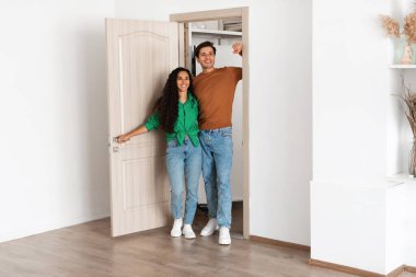 Mutlu çift yeni evlerine adım atıyor, şık tasarımı keşfetmek ve yeni yaşam alanlarını kucaklamak için sabırsızlanıyorlar. Bu dönüm noktasından birlikte keyif alırken gülümsemeyi paylaşıyorlar..