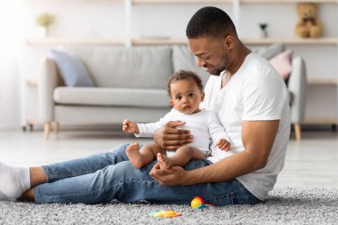 Babalık izniniz kutlu olsun. Genç, siyah bir babanın evde tatlı bir bebekle bağ kurması, Afrika kökenli mutlu bir Amerikalının babasının tatlı küçük çocuğuyla oturma odasında dinlenmesi, boşluğu kopyalaması.