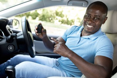 Yeni arabasının otomatik anahtarını gösteren mutlu siyah bir adam. Neşeli Afro-Amerikan şöför araba kiralama veya satın alma, oto kuaför veya kiralama hizmeti önerme, fotokopi alanı