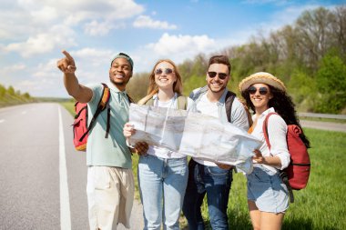 Bir grup çok ırklı arkadaş haritayı kontrol ediyor, yolculuk sırasında güzergah seçiyor, otostop çekiyor. Otomatik yolculuk, yaz tatili, seyahat tutkusu, özgürlük ve arkadaşlık kavramı.