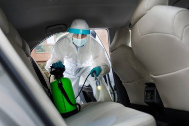 Koruyucu giysili, maske dezenfekte eden, sık sık dokunulan temiz yüzeyleri silen, covid-19 virüsü enfeksiyonunu önleyen, mikrop veya bakteri bulaşmasını önleyen, yeni normal yüzeyler.