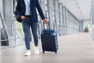 Tanımlanamayan bir adam, günlük kıyafetleriyle havaalanı terminalinde dolaşırken, erkek yolcu bavuluyla biniş kapısına giderken, iş seyahatine ya da tatil seyahatine çıkarken,