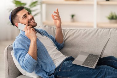 Akıllı telefonla konuşan neşeli heyecanlı milenyum adamının portresi, emniyet müdürünü koltukta otururken kullanmak. Mutlu genç yahudi erkek arkadaşlarıyla sohbet ediyor. İşten kaytarıyor.