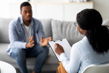 Psikolojik yardım. Depresyonda olan Milenyum siyahi bir adam ofisteki terapistle terapi seansı yapıyor. Klinikteki psikiyatristten yardım alan duygusal sorunları olan umutsuz genç adam.