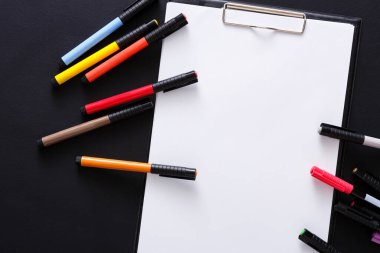 Çizim için-ileti örneği renk işaretleyicilerini çeşitli görünümünü üst ve beyaz boş kağıt üzerinde siyah okul sırası geçmiş ile tablet. Desiner çalışma alanı sketchbook, closeup üzerinde kopya alanı ile