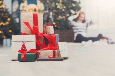 Kış tatil arka plan. Noel hediye kutuları bant ile dekore edilmiş xmas ağacı ve mutlu genç kız zemin kırmızı kurdele portre. Seçici odak, kopya alanı