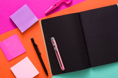 İleti örneği, modern yaratıcı çalışma alanı. Siyah sayfaları, pembe makas, office bıçak, çok renkli arka plan, üstten görünüm, kopya alanı işaretçisi ve Not notları ile şık açık not etmek