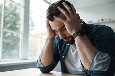 Hayal kırıklığı, yorgunluk ve baş ağrısı. Endişe ve agorafobi. Üzücü heyecanlı, bin yıllık yakışıklı sakallı adam elleri oturma odasının iç tarafında, pencerenin yanında, kapat.