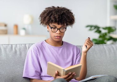 Ders kitabı okuyan, evde ders çalışan, sınava hazırlanan ciddi siyahi gençler. Zeki Afrikalı Amerikalı ergen, koronavirüs izolasyonu sırasında uzaktan öğreniyor.