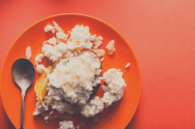 Sağlıklı Kahvaltı, diyet ve detoks kavramı - parlak turuncu zemin üzerine plaka üzerinde taze peynir. Natürmort, düz yatıyordu, en iyi görünüm, kopya alanı