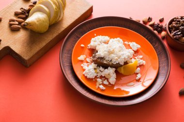 Sağlıklı Kahvaltı, diyet ve detoks kavramı - tabak, kase fındık ve ahşap tahta ile meyve parlak zemin üzerine taze peynir. Natürmort, düz yatıyordu.