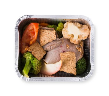 Sağlıklı beslenme konsepti. Folyo kabında öğle yemeği, restoran yemekleri. Kilo verme diyeti. Kaynamış karnabahar, brokoli ve beyaz arka planda taze domates ile buharda pişirilmiş dana eti, yakın plan, izole edilmiş