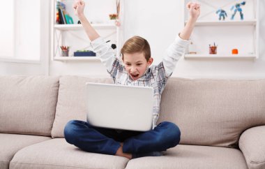 Online oyunu kazanmak. Becerikli alet ve teknoloji gençler kavramı, evde oturma odasında kanepede otururken internet oynamak için