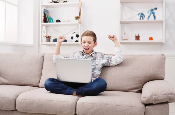 Online oyunu kazanmak. Becerikli alet ve teknoloji gençler kavramı, evde oturma odasında kanepede otururken internet oynamak için