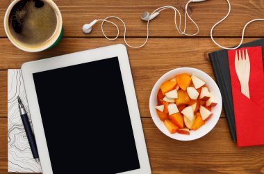 Sağlıklı öğle yemeğinde işyeri ile kopya alanı tablet PC'de. Üstten Görünüm düz masaüstü meyve salatası folyo konteyner ve cep telefonu ahşap Resepsiyon arka plan üzerinde yatıyordu