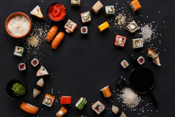 Suşi ve rulo arka plan, siyah, en iyi görünüm, kopya alanı sınırında. Renkli Japon restoranı Mama seti