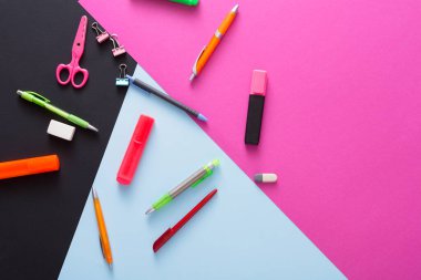 Kalemler, keçeli kalemler, makas ve yapışkan notlar da dahil olmak üzere parlak kırtasiye malzemeleri renkli bir arkaplanda düzenlenir. Bu kurulum, yaratıcılık için ideal, oyuncu ve sanatsal bir çalışma alanını gösteriyor.