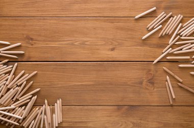 Çeşitli ahşap renkli kalemler, sanatsal yaratıcılık için ilham verici bir çalışma alanı sunan kırsal ahşap bir masaya saçılmıştır. Kalemler kaotik bir şekilde düzenlenir, hayal gücüne davet edilir..