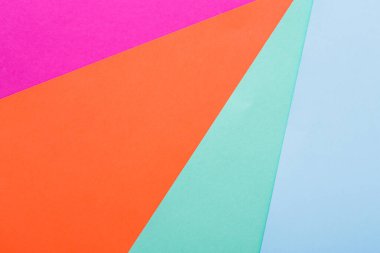 Pembe, turuncu ve mavinin canlı tonlarında çeşitli renkli kağıtlar düzgünce düzenlenmiştir. Bu kurulum sanat projeleri, tasarım ilhamı veya zanaat faaliyetleri için idealdir..