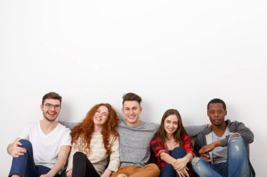 Mutlu gülen arkadaşlar, farklı öğrencilerin kapalı mekanlarda takılması. Beyaz arkaplan, alanı kopyala