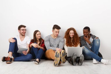 Mutlu gülen arkadaşlar, farklı öğrencilerin evde birlikte zaman geçirmesi. Dizüstü bilgisayarda video izleyip konuları tartışıyoruz. Beyaz arkaplan, alanı kopyala