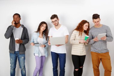 Aletleri olan çok ırklı genç öğrenciler, içeride buluşuyorlar. Modern eğitim teknolojileri.