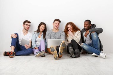 Mutlu gülen arkadaşlar, farklı öğrencilerin evde birlikte zaman geçirmesi. Dizüstü bilgisayardan film izliyorum. Beyaz arkaplan, alanı kopyala