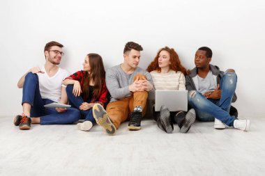 Arkadaşlar, farklı öğrencilerin evde birlikte zaman geçirmesi. Dizüstü bilgisayarda video izleyip konuları tartışıyoruz. Beyaz arkaplan, alanı kopyala