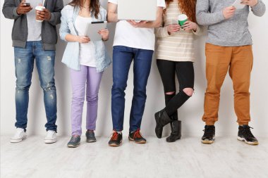 Aletleri, bacakları ve iç mekanları olan çok ırklı genç öğrenciler. Modern eğitim teknolojileri.