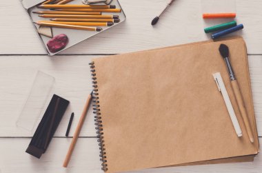 Sanatçı çalışma alanı arka plan. Suluboya boya ve boş Kraft kağıt Beyaz ahşap masa, üstten görünüm, düz yatıyordu alanı Kopyala