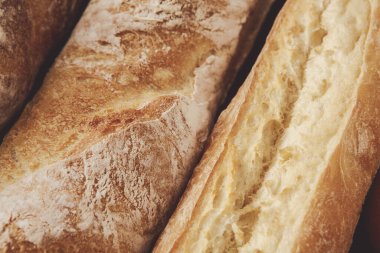 Bir fırında birkaç taze ekmek somunu yan yana dizilir. Altın kabuklar yumuşak, hafif iç kısımlarla tezat oluşturur ve müşterileri sıcak aromalarının tadını çıkarmaya davet eder..