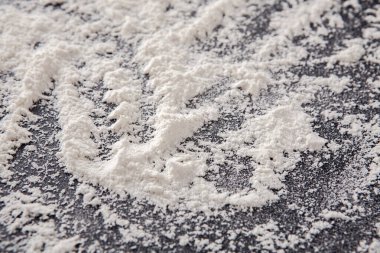 İnce un koyu bir tezgahın üzerinde duruyor, karıştırma ve pişirmeden dolayı yoğurma izleri ortaya çıkıyor. Doku, yaratıcılık ve sıcaklıkla dolu yeni bir aşçılık projesine işaret ediyor..