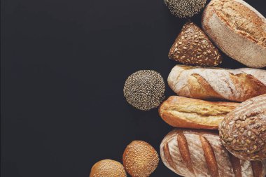 Fırın arka plan, siyah izole ekmek ürün yelpazesine sahip. Kopya alanı ile Üstten Görünüm